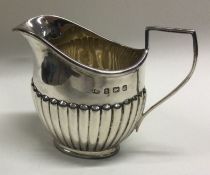 A small silver half fluted cream jug. Birmingham. Approx. 67 grams. Est. £30 - £50.