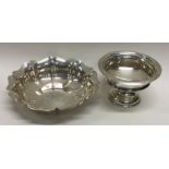 A circular silver bon bon dish together with one other.