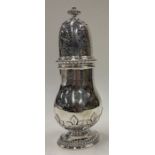 A fine chased silver sugar caster. London 1935. Retailed by Harrods.