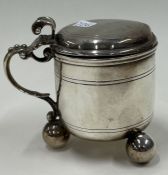 A Victorian silver and glass mustard pot on feet. London 1874.