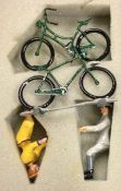 Four painted lead figures together with push bikes.
