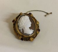 A fine quality Georgian gold shell cameo with garnet decoration to frosted leaves.