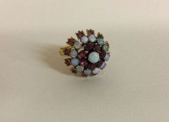 An opal and ruby cluster ring in 14 carat mount.