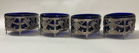 A set of four pierced French silver and glass table salts.