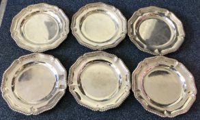 A set of six Victorian silver dinner plates with central armorials. London 1892. By Robert Garrard.