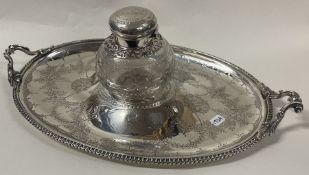 A decorative Victorian silver and glass inkwell on handled tray. London 1878. By Edward Ker Reid.