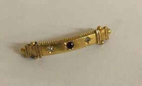 A 15 carat gold ruby and diamond three stone brooch.