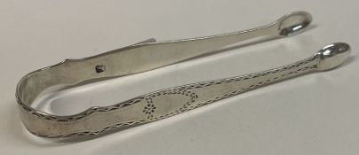 A pair of 18th Century bright-cut silver tongs. Maker and lion only. By IS.