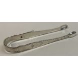 A pair of 18th Century bright-cut silver tongs. Maker and lion only. By IS.