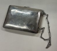 An American engraved silver bag and compact attached on a suspended chain.