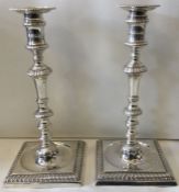 A very fine and heavy pair of silver cast candlesticks with square base. London 1758.