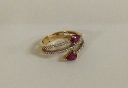 An attractive ruby and diamond crossover ring in 1