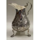 A heavy Victorian silver cream jug chased with flowers and leaves. London.