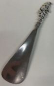 A fine silver shoe horn with figural terminal depicting 'Punch'. Birmingham 1901.
