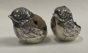 A good quality silver pin cushion in the form of a chick together with one other.