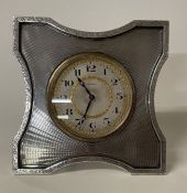 A large engine turned silver clock. London 1925. By Goldsmiths.