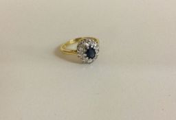 An attractive oval sapphire and diamond cluster ring in 18 carat gold.