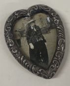 A Victorian chased silver heart shaped photo frame. Birmingham 1899.
