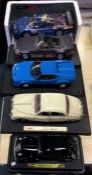 Four 1:18 scale unboxed model cars together with one other.