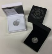 A boxed silver Proof sovereign together with one other.