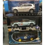 Three boxed 1:18 scale model cars.