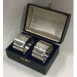 A cased pair of engine turned silver napkin rings. Birmingham 1937. By C&N.