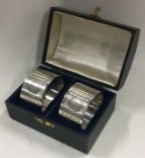 A cased pair of engine turned silver napkin rings. Birmingham 1937. By C&N.