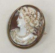 A shell cameo of a lady in gold frame.