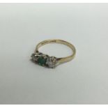 An 18 carat gold emerald and diamond three stone ring in claw setting.