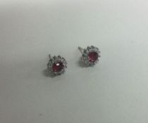 A pair of silver and gem set cluster earrings.