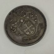 A heavy silver medallion with crested decoration.