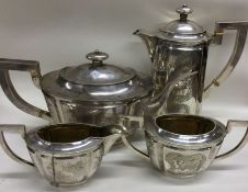 An early 20th Century Chinese export four piece silver tea set engraved with flowers and bamboo.