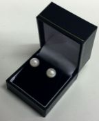 A pair of 9 carat pearl mounted ear studs.