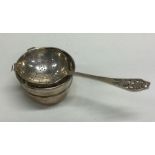 A silver pierced tea strainer on stand. Sheffield 1942. By Emile Viner.