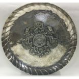 A large chased silver dish with central armorial. Approx. 630 grams.