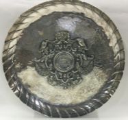A large chased silver dish with central armorial. Approx. 630 grams.