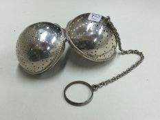 An American silver tea infuser / pomander with suspension chain. Marked to side.