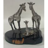 A group of three silver African giraffe on a stand. Approx. 238 grams. Est. £300 - £500.