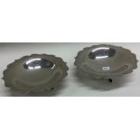 A good pair of silver circular pin dishes on three spreading supports.