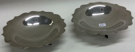 A good pair of silver circular pin dishes on three spreading supports.