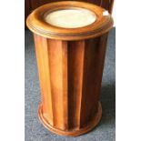 A cylindrical marble top wash stand with fluted si