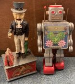 A cast iron money box together with a toy robot.