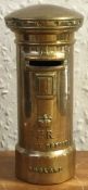 A heavy brass money box in the form of letter box.
