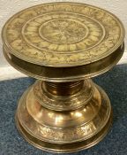 A large Antique circular brass stand attractively decorated with scrolls and flowers.