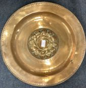 A good Antique brass alms dish attractively decorated with scrolls and leaves.