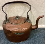 An Antique copper kettle with cast iron swing handle.
