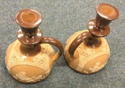 A pair of Royal Doulton candlesticks decorated with scrolls.