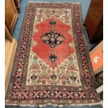 A good red tapestry rug with floral border and central medallion.