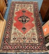 A good red tapestry rug with floral border and central medallion.