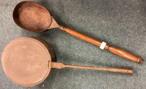 An Antique copper warming pan with steel handle together with one other.